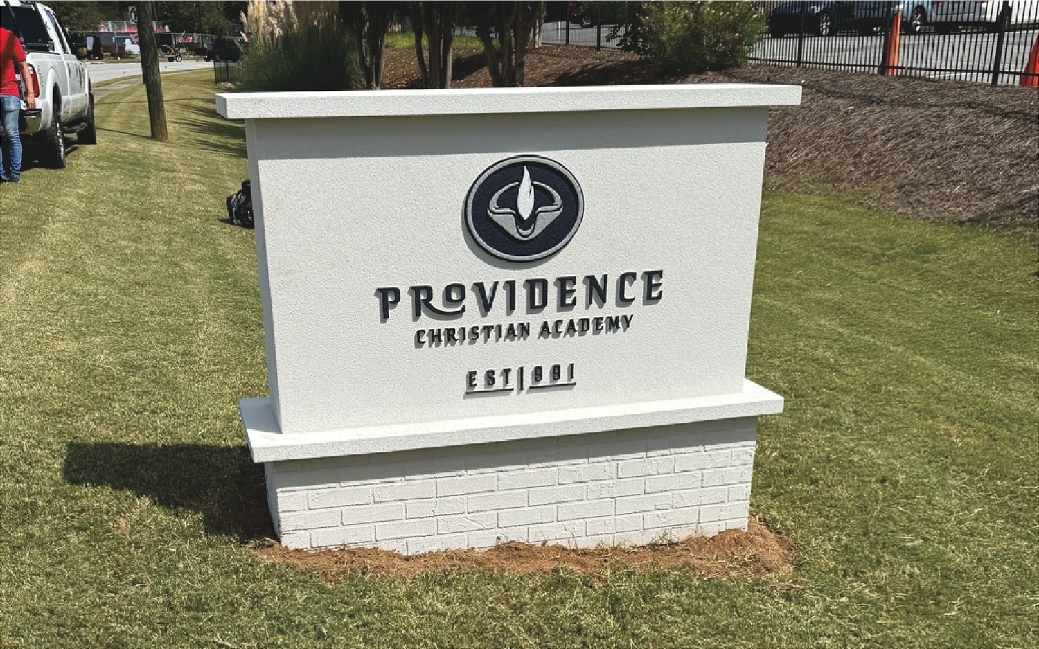 Vehicle parked on grassy land near fence